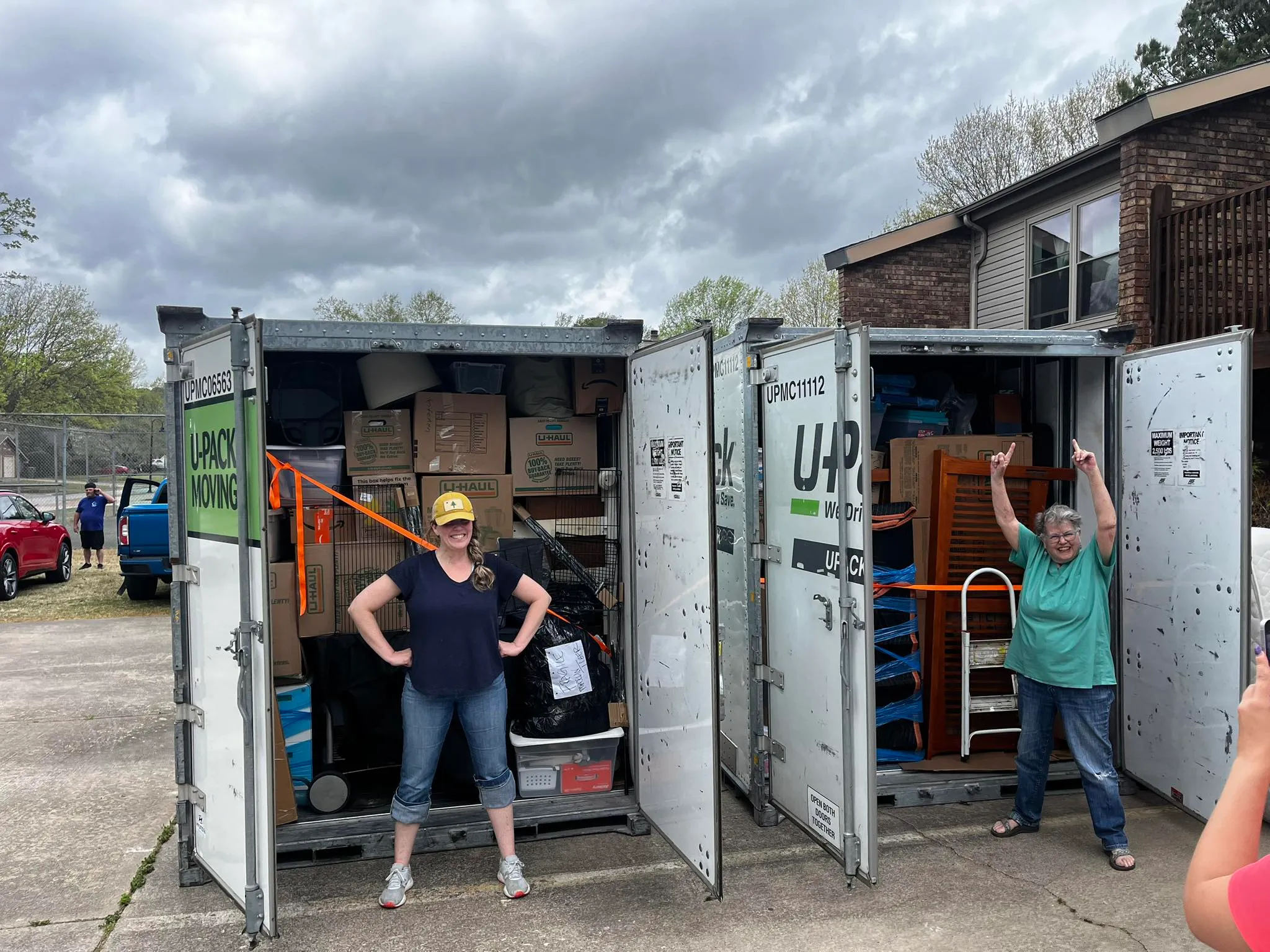 Happy JB's Precision Moving customers with loaded moving containers